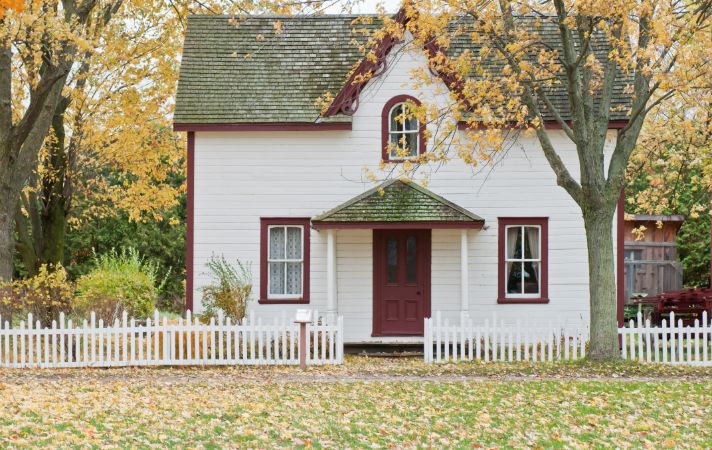 Traditional detached home with front garden and picket fence, symbolising freehold property ownership in the UK
